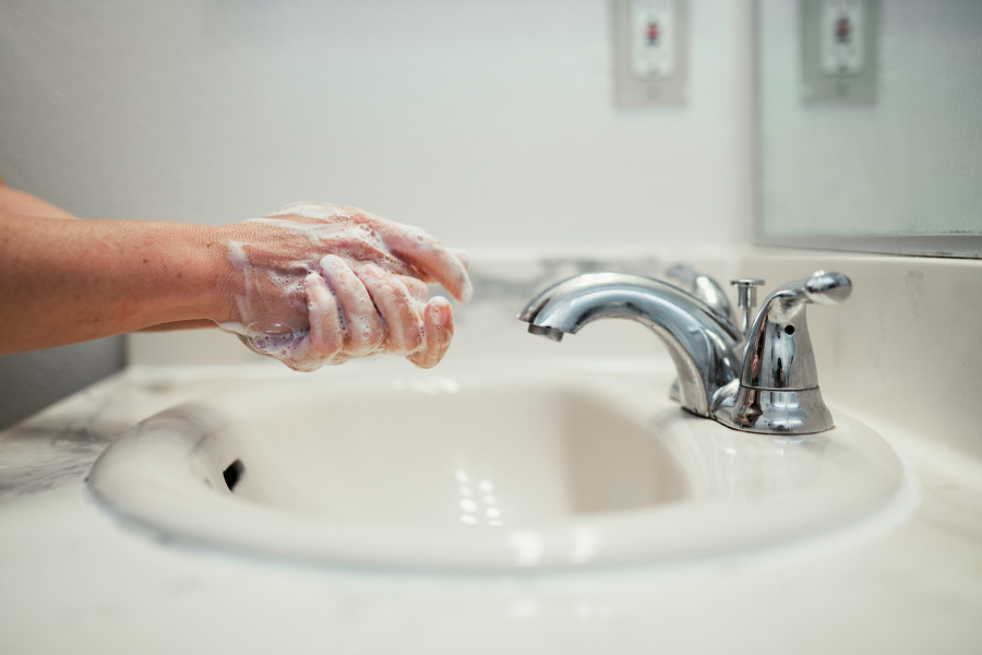 Handwashing over the sink with soap to protect from coronavirus infection