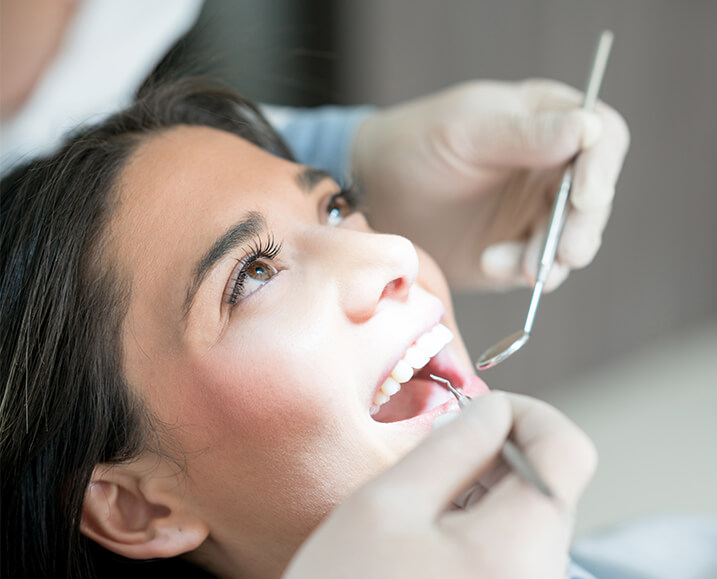 woman having her teeth examined by a dentist